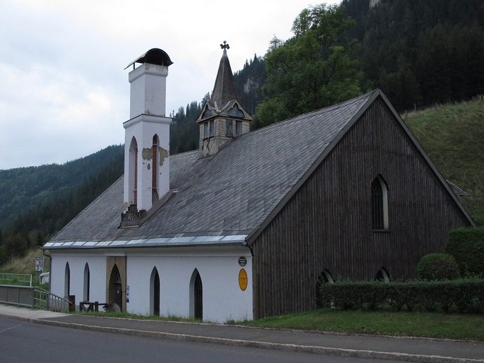 Die Lehrfrischhütte in Vordernberg: ein holzverschalter Bau mit hohem weißem Kamin und Dachreiter